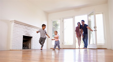 man, woman, and two children walk through the door of an empty room